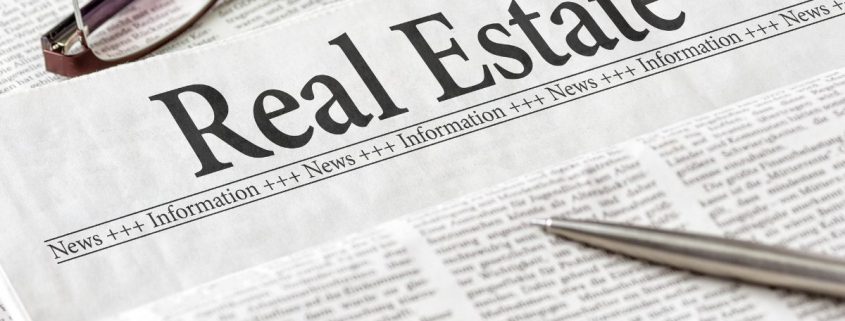 Real Estate Newspaper section black and white with glasses in frame