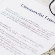 commercial lease document with money and glasses sitting on desk