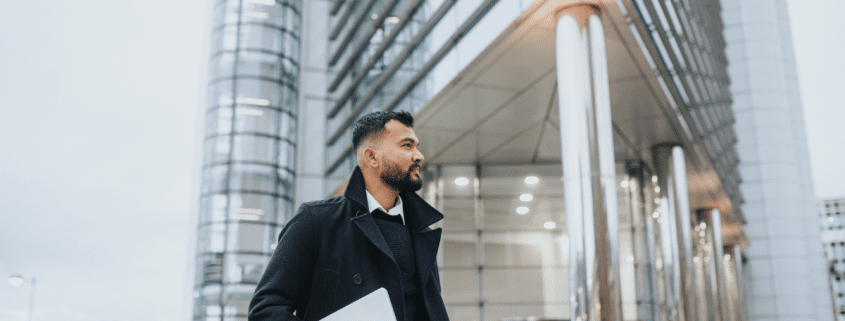 Entrepreneur walking downtown in front of commercial building on the phone