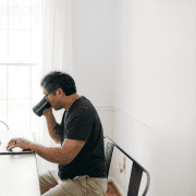 man sitting at desk drinking coffee working from home on a hybrid schedule