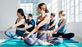 men and woman stretching in yoga class