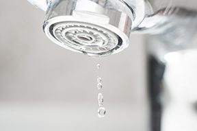 faucet with several drops of water instead of flowing water