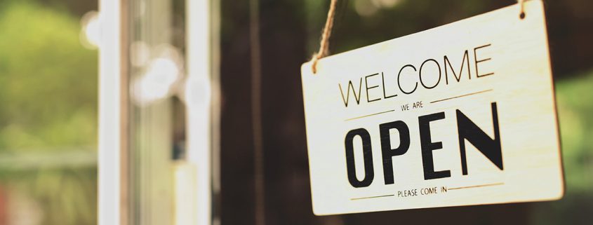 Welcome open sign on shop door. Text on cafe front or restaurant
