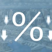 percent symbol surrounded by down arrows on a faded blue background of the San Diego skyline