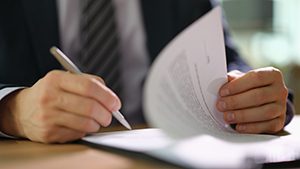 Businessman in suit signing document at work in office closeup. Earning strategies in business financial deals concept as_587214355