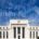 Interest Rate reduction graph and city skyline overlay on Federal Reserve Building