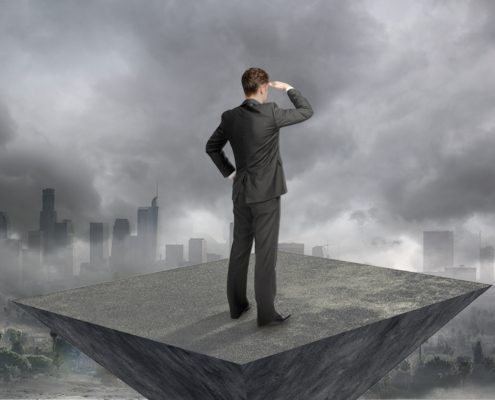 Decision maker looking out over a city with clouds interfering with his view