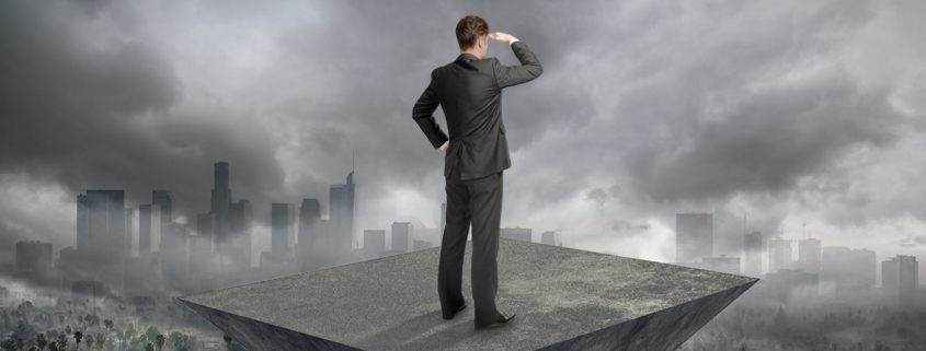 Decision maker looking out over a city with clouds interfering with his view