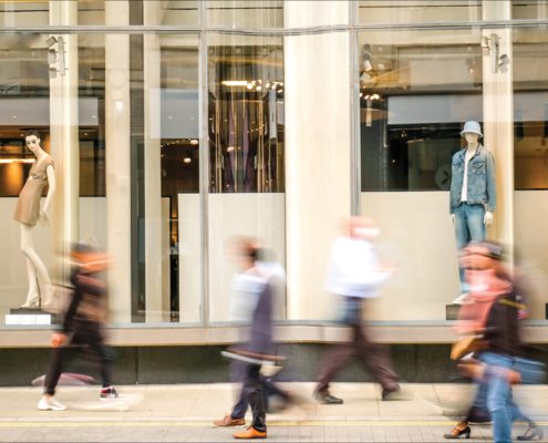 Blurred people walking past a retail department store