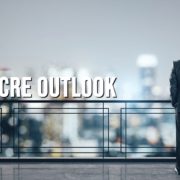 2026 CRE Outlook overlay on photo of businessman on balcony looking at skyline