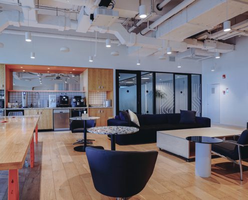 Modern office lounge with movie screen and meeting areas