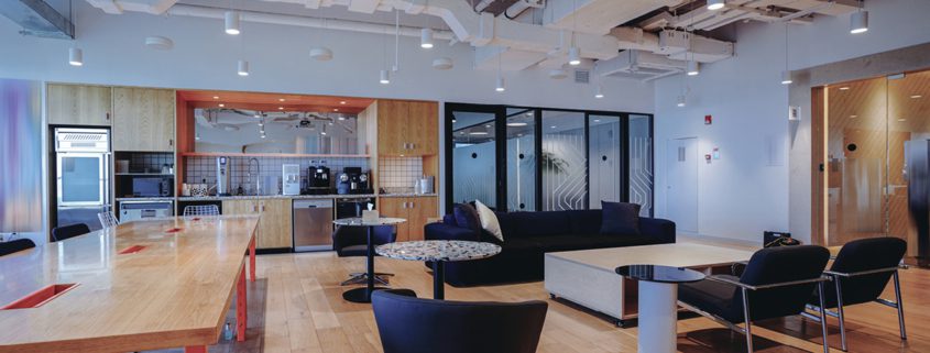 Modern office lounge with movie screen and meeting areas