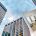 hand holding an apartment rendering over an office buildings pending conversion to multifamily housing