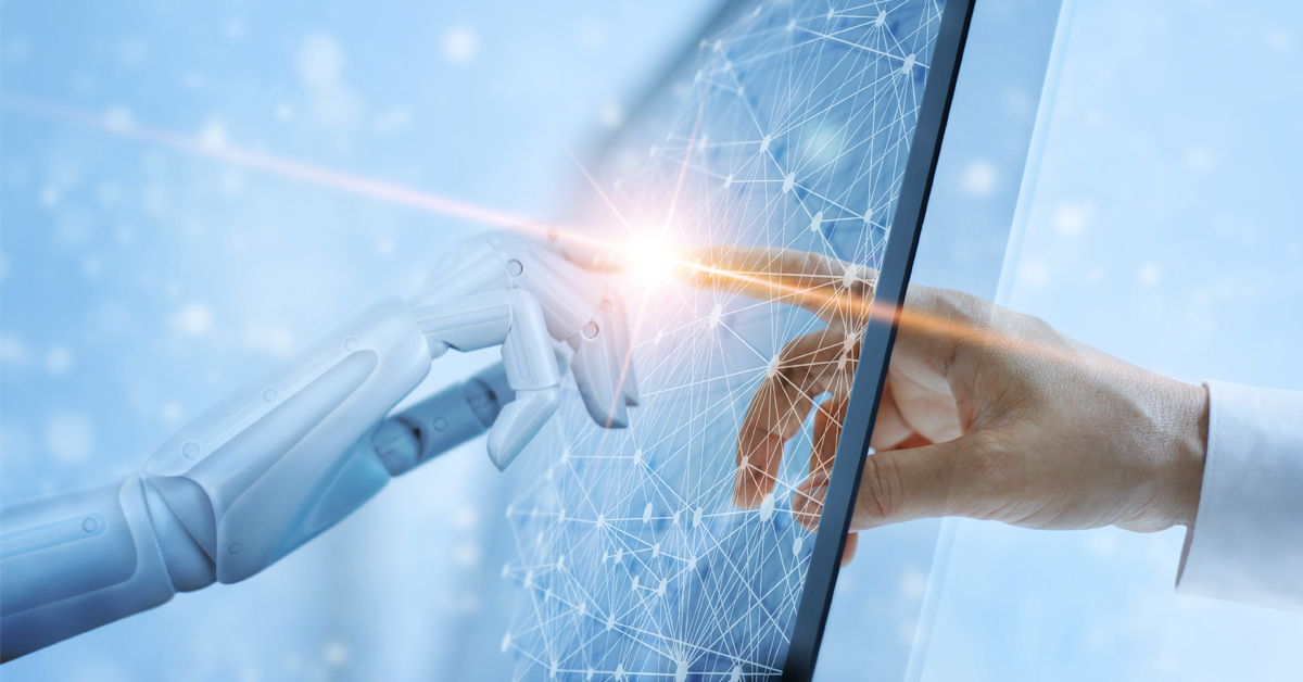 Robot and human hand connecting on a computer screen with a glowing light