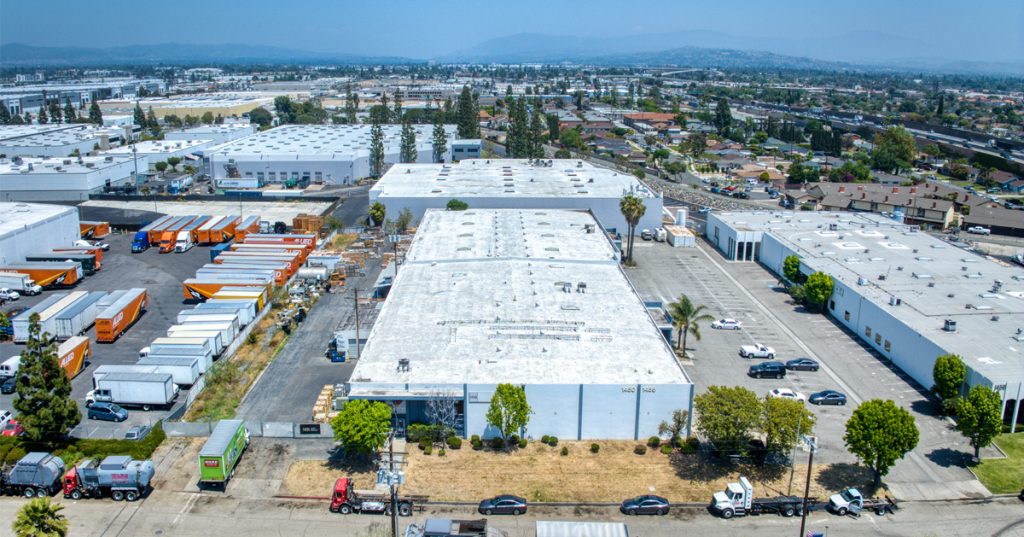 Oblique close up aerial of the side of the building showing both the front parking lot and rear dock door loading area