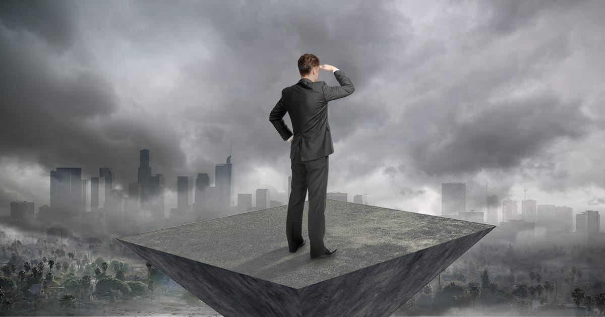 Decision maker looking out over a city with clouds interfering with his view