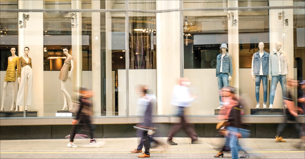Blurred people walking past a retail department store