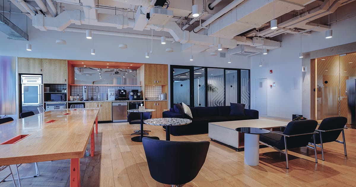 Modern office lounge with movie screen and meeting areas